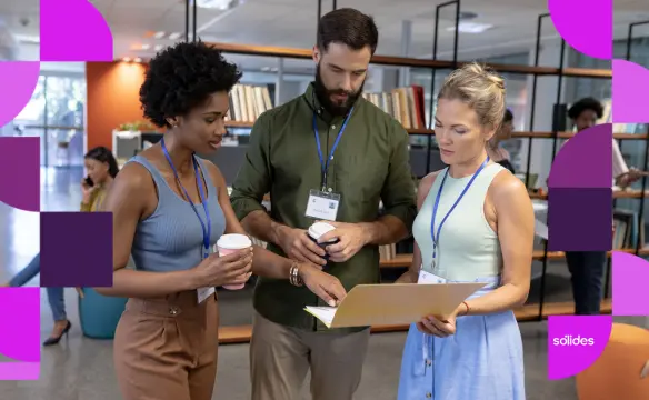 Três profissionais de Recursos Humanos em pé em um escritório moderno, usando crachás e analisando juntos documentos em uma pasta amarela, representando a gestão e planejamento de férias compulsórias na empresa.