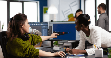 Pessoas gesticulando em frente a computador em ambiente empresarial representando a rotina de um Tech Recruiter