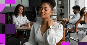 Mulher jovem em ambiente de escritório, sentada à mesa com os olhos fechados e a mão no pescoço, expressando cansaço mental ou estresse. Ao fundo, colegas de trabalho e elementos gráficos da Sólides