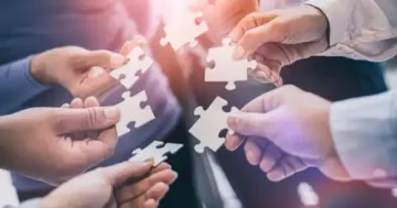 Imagem ilustra uma equipe juntando as peças, mostrando como o trabalho em equipe de uma equipe de alto desempenho pode ser feito