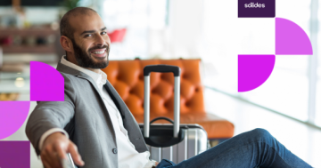 Homem sorridente sentado com uma mala de viagem em um saguão, representando um colaborador em descanso devido a uma escala de férias bem planejada pela empresa, com grafismos roxos e rosa da Sólides ao fundo