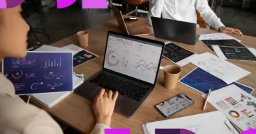 Analista de RH visualizando dashboards de indicadores em um laptop, cercada por relatórios e gráficos impressos sobre uma mesa de madeira, em um ambiente de escritório moderno. A imagem apresenta elementos gráficos em tons de roxo e rosa nas extremidades e o logotipo da Sólides no canto inferior direito.