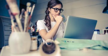 mulher em frente ao computador estudando a diferença entre gestão por competências e gestão por desempenho