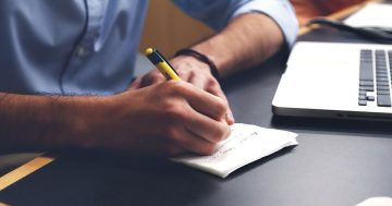 representação de uma pessoa anotando os passos para implementar a gestão por competências