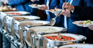 Pessoas se servindo em um buffet, representando o que é intervalo Intrajornada.