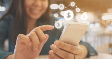 Imagem mostra uma mulher mexendo no seu celular e várias cifras aparecendo para ela, simulando, O que é o salário emocional
