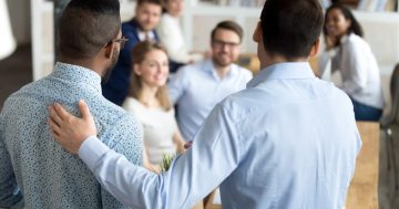 dois homens de costas mas de frente para outras pessoas
