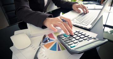 representação de um contador trabalhando com computador e calculadora
